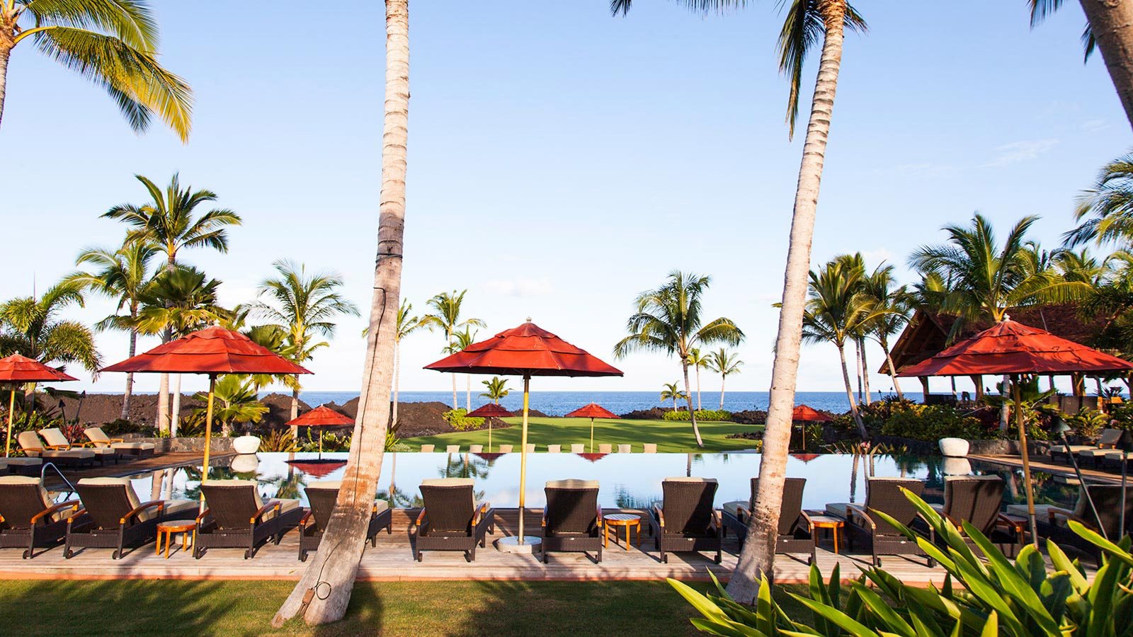 A pool deck with the ocean in view