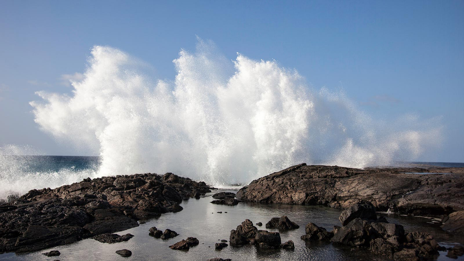 Crashing waves send cooling salt spray into the breeze