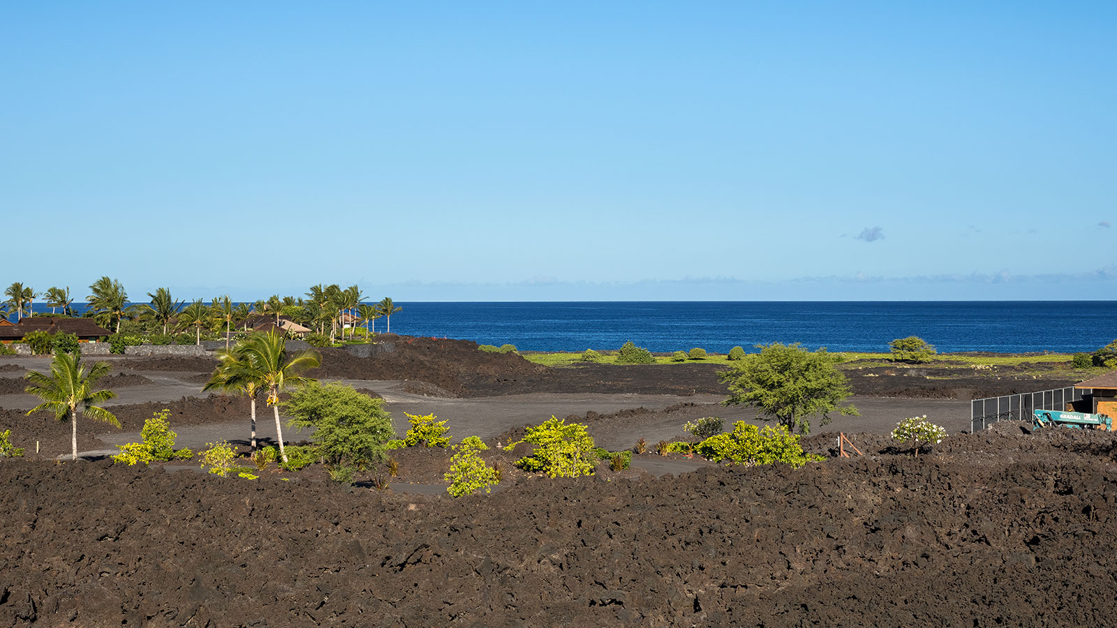 A dramatic landscape of black lava and lush green