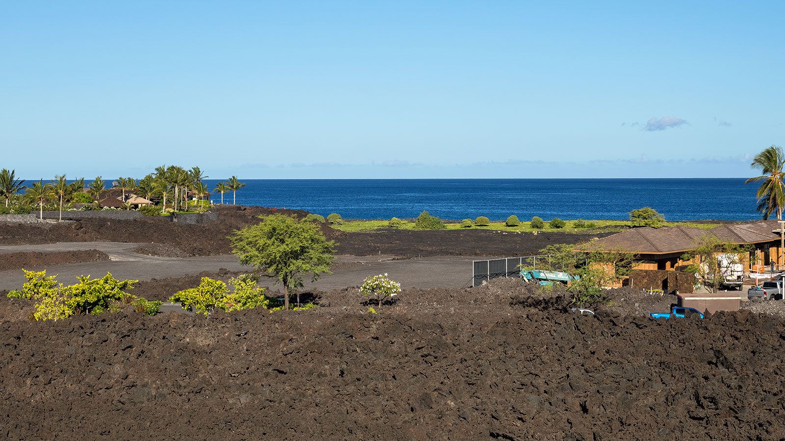 A dramatic landscape of black lava and lush green