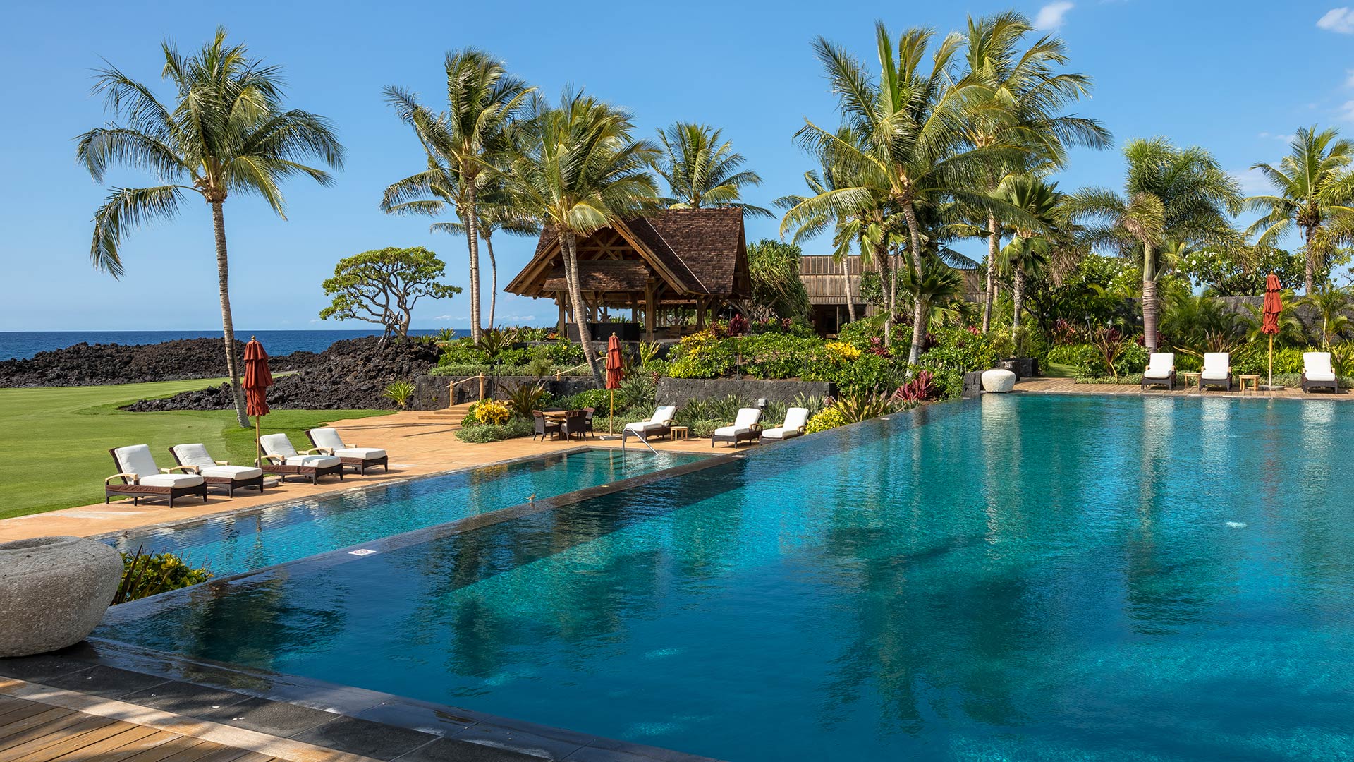Tranquil waters of the luxury pool, steps from the ocean’s rolling waves